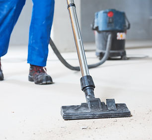 Person vacuuming a floor at a construction site