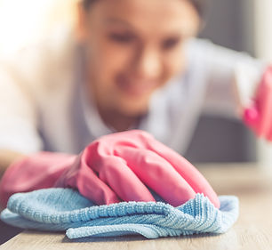 Woman wearing gloves cleaning a surface